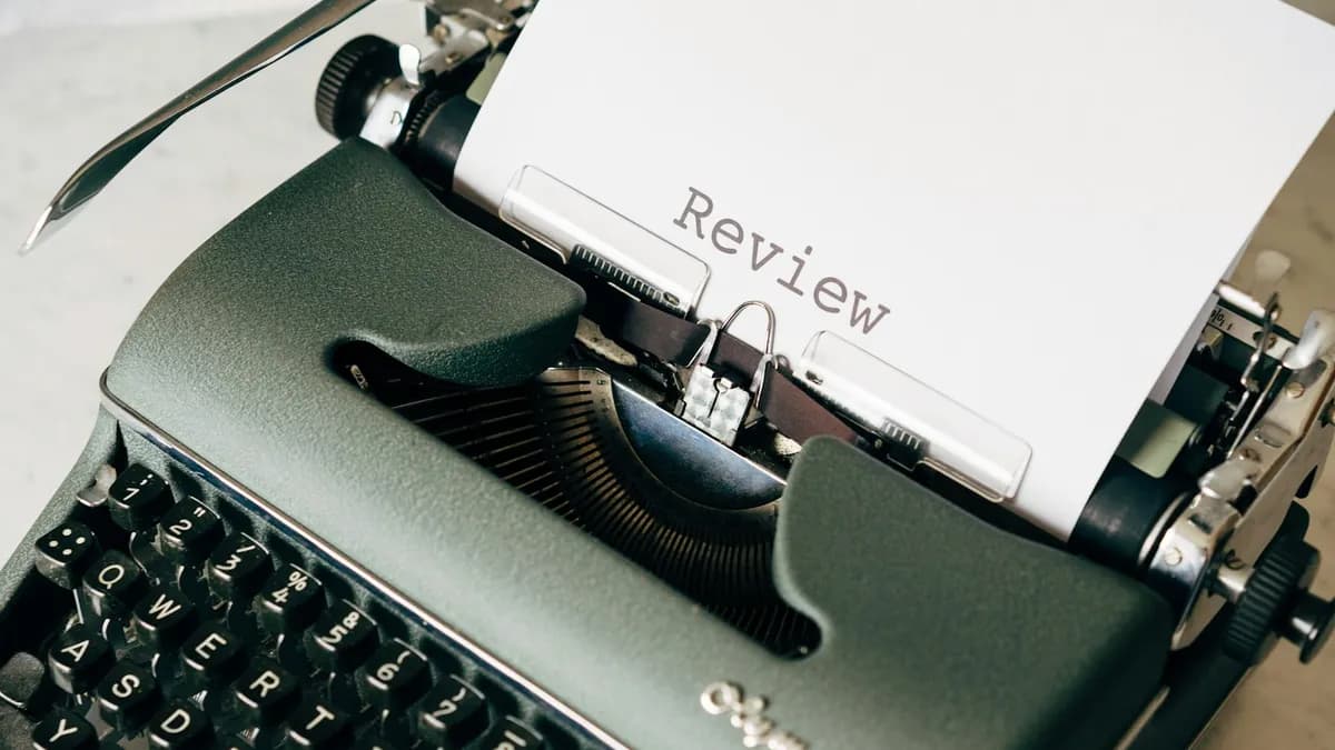 Persoon die aan een tafel online reviews van een ADHD-coach leest op een laptop en smartphone