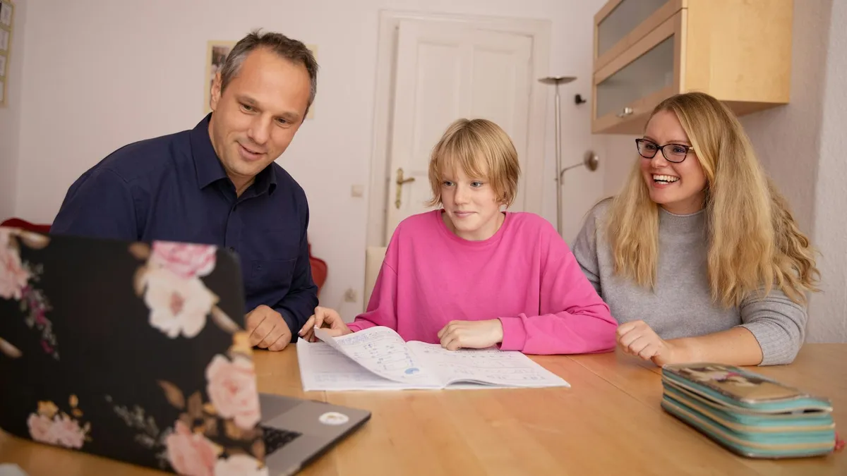 Ouder en kind maken samen een dagplanning aan de keukentafel