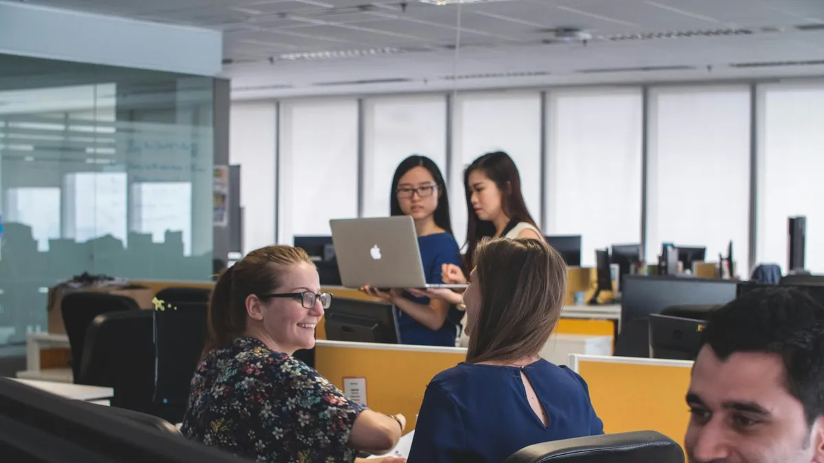 Werknemer aan een bureau die met notities en een planner structuur zoekt in het werk