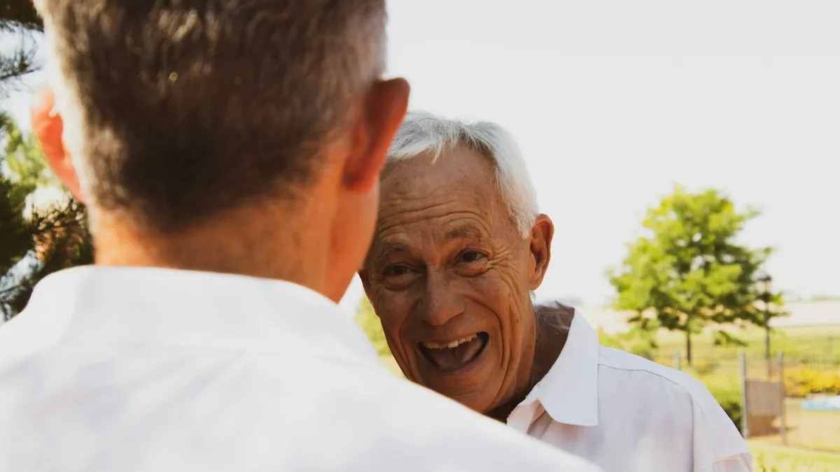 Volwassen dochter in gesprek met haar oudere moeder aan de keukentafel