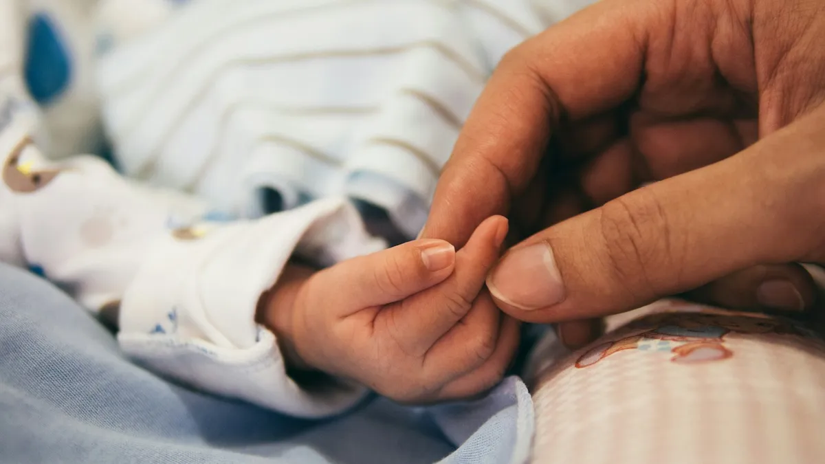 Ouder met een baby bij een zorgverlener in een rustige praktijkruimte