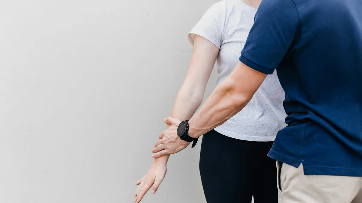 Chiropractor die de rug van een patiënt onderzoekt tijdens een consultatie