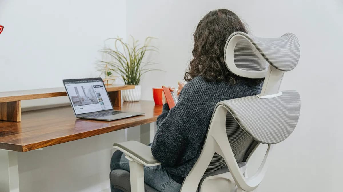 Thuiswerker met rugpijn aan een bureau, met aandacht voor houding en beweging
