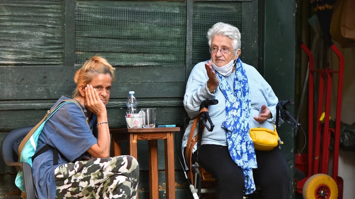 Volwassen dochter in gesprek met haar oudere moeder aan de keukentafel