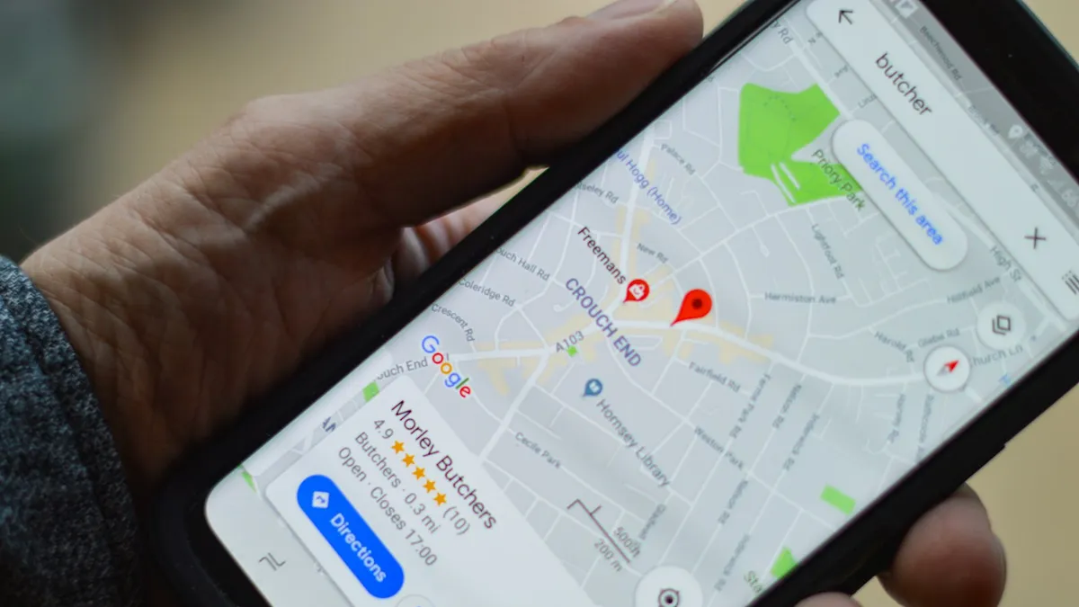 Persoon leest online reviews over een dermatoloog op een smartphone aan de keukentafel