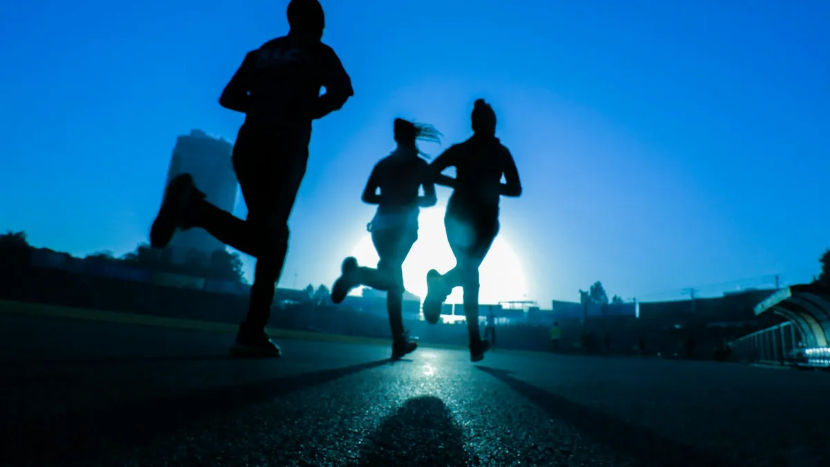 Persoon met een glucosesensor op de arm die buiten aan het joggen is