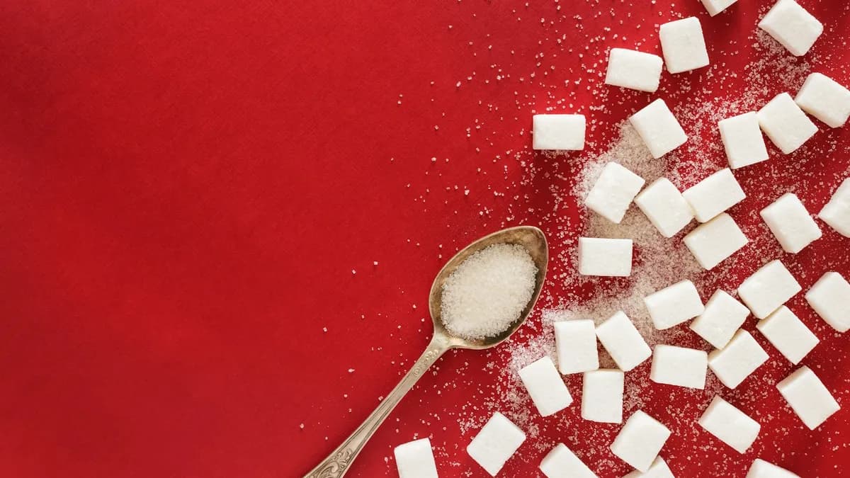 Persoon meet de bloedsuiker met een glucosemeter aan de keukentafel