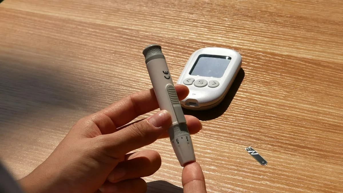 Kind met diabetes controleert de glycemie met een sensor, samen met een ouder aan de keukentafel