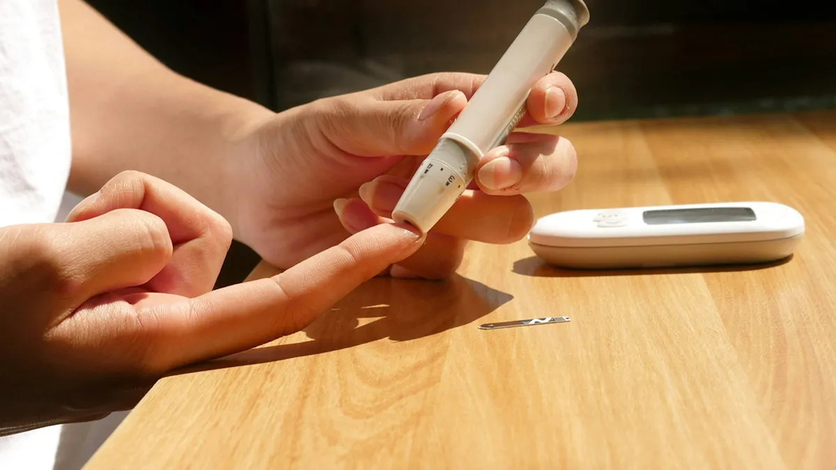 Volwassene met een glucosesensor op de arm tijdens een gesprek met een zorgverlener