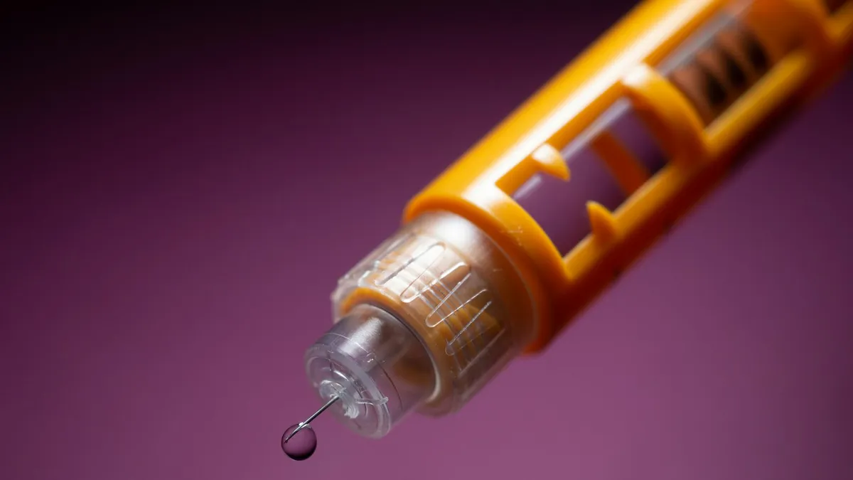 Persoon met diabetes bekijkt een glucosesensor en insulinepomp tijdens een consult bij de diabetoloog