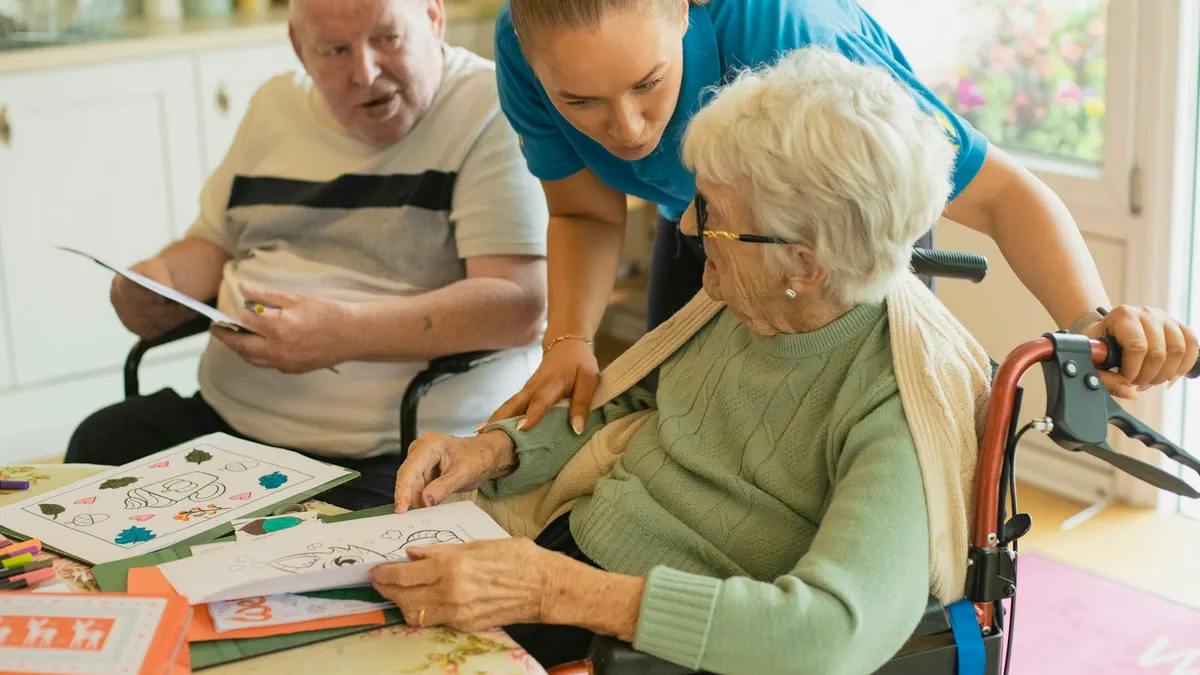 Ergotherapeut bespreekt dagelijkse activiteiten met een oudere persoon aan tafel