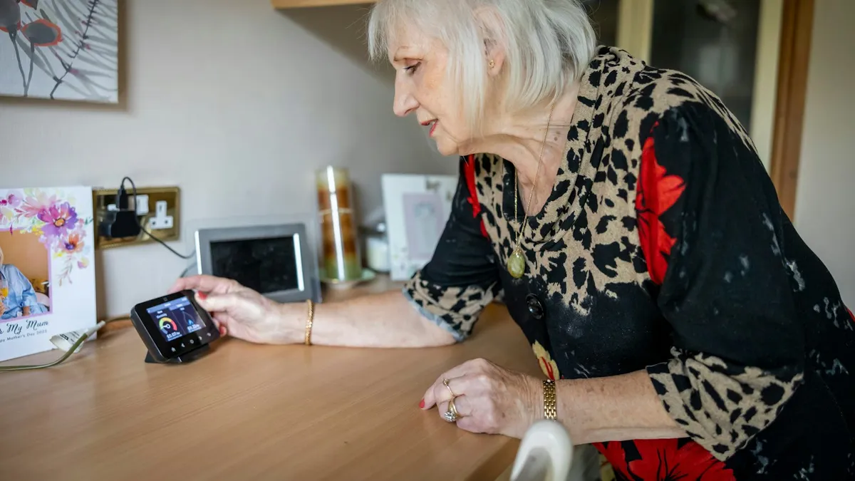 Oudere persoon gebruikt een tablet in een aangepaste woning