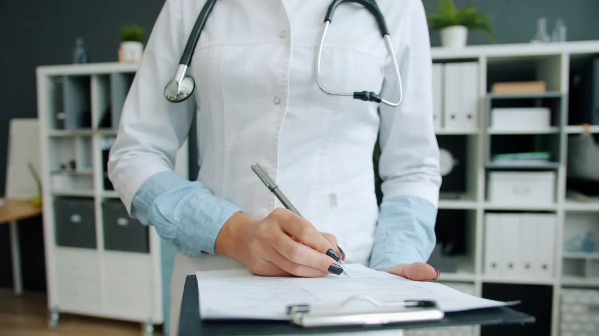 Huisarts schrijft een voorschrift voor kinesitherapie uit tijdens een consult