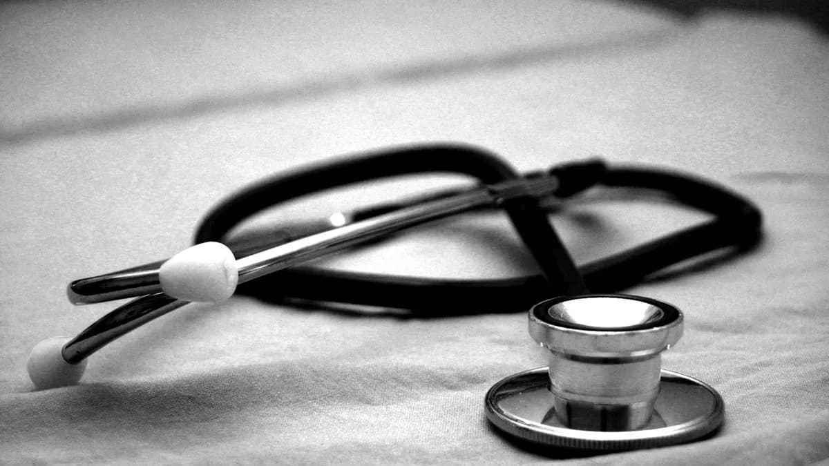 Oudere persoon en mantelzorger bereiden samen documenten voor aan de keukentafel voor een bezoek aan de geheugenkliniek