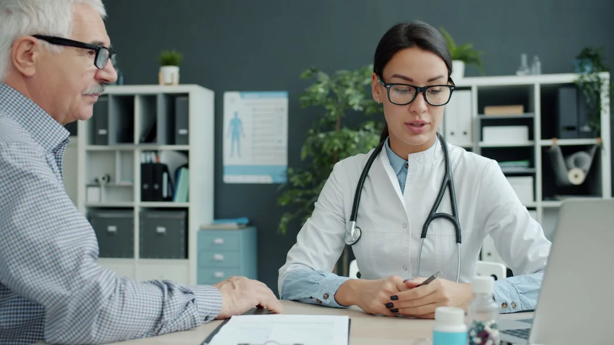 Oudere persoon en mantelzorger bereiden samen documenten voor een afspraak bij de geriater voor
