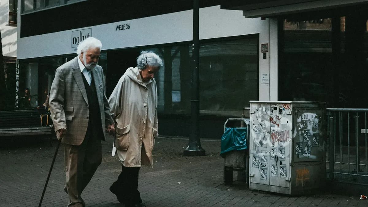 Oudere persoon krijgt hulp bij het rechtstaan na een val in de woonkamer