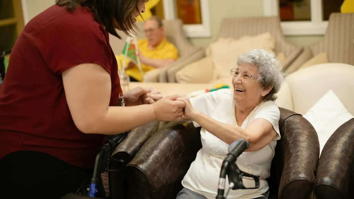 Mantelzorger bespreekt oefeningen met een oudere persoon en een geriatrische kinesitherapeut