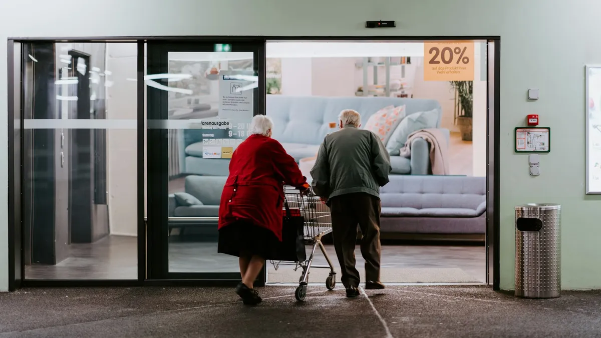 Kinesist begeleidt een oudere persoon bij oefeningen tijdens een sessie aan huis