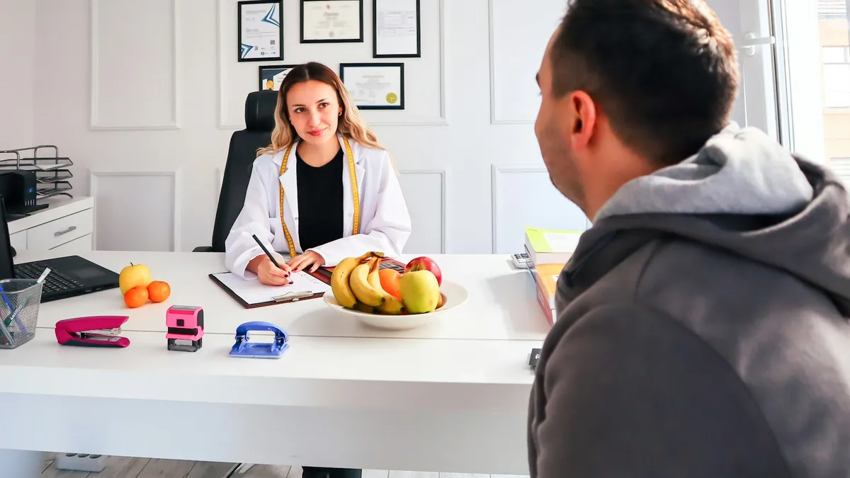 Coach en cliënt bespreken gezondheidsdoelen aan een tafel zonder medische handelingen