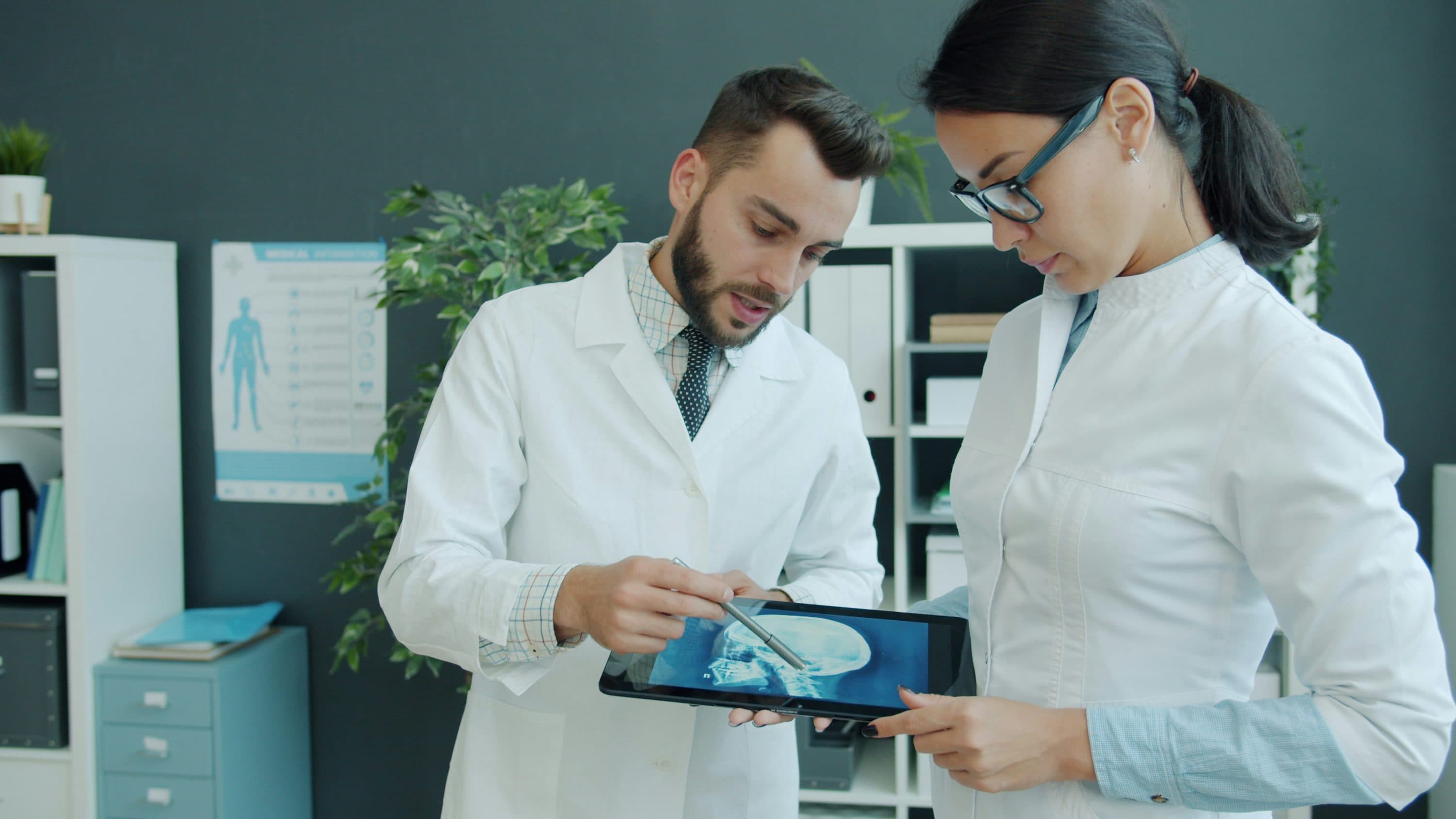 Twee artsen bekijken samen een medische scan op een tablet