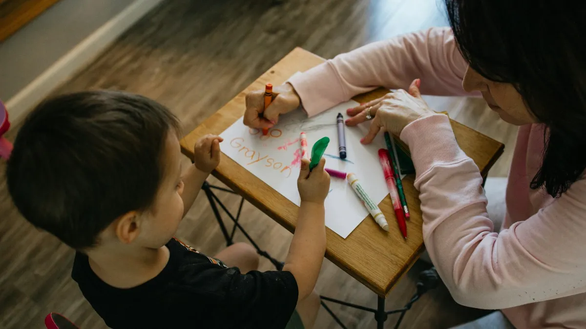 Kind en therapeut aan een lage tafel tijdens een sessie kindertherapie