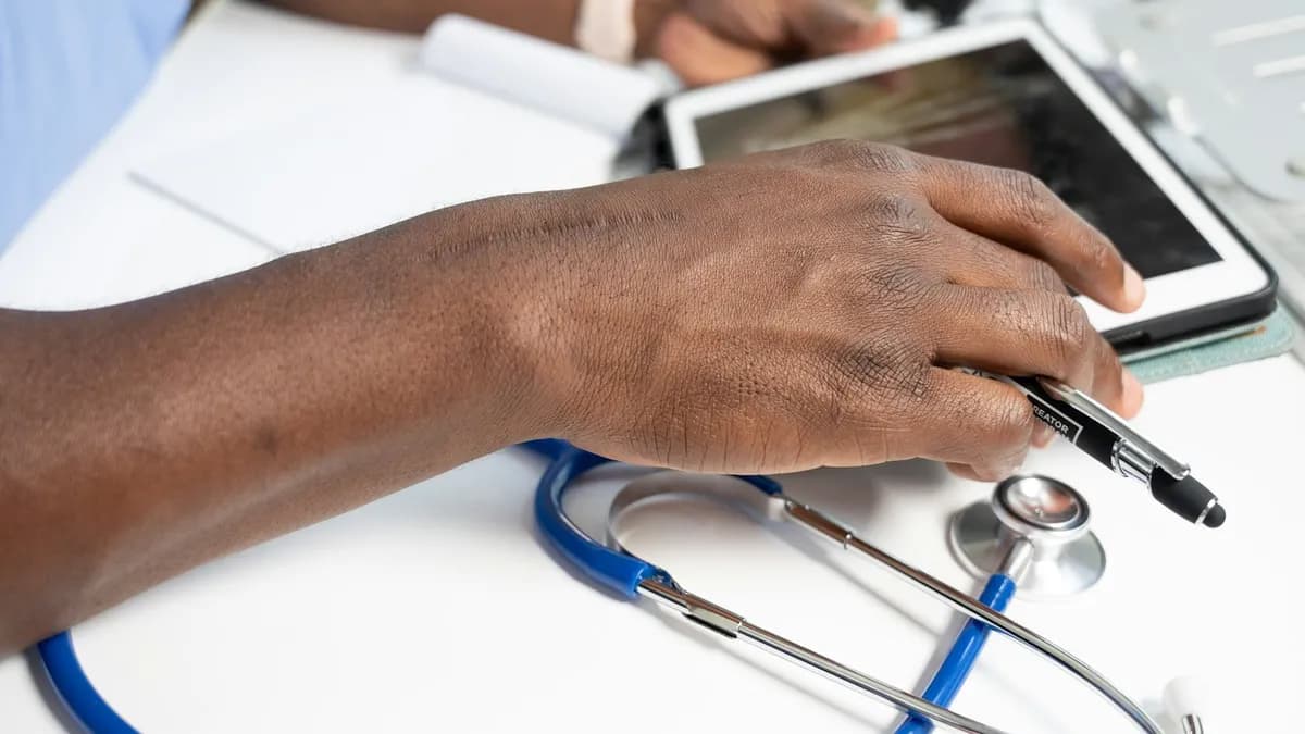Persoon bereidt vragen en documenten voor aan een tafel voor een eerste gezondheidsgesprek