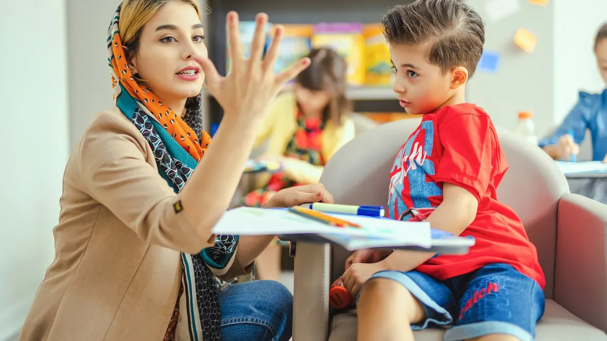 Leerkracht, ouder en logopedist overleggen aan een schooltafel