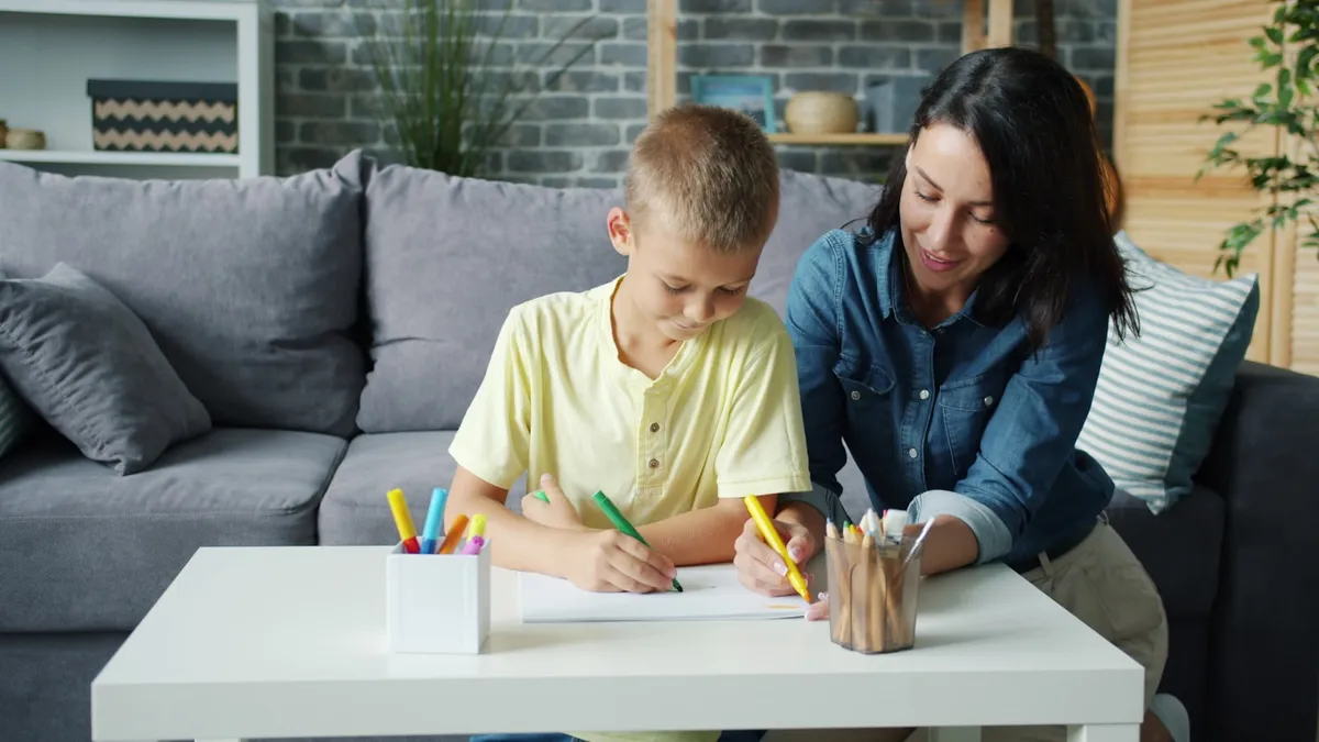 Ouder en kind oefenen samen rustig aan tafel met kaartjes en een schrift