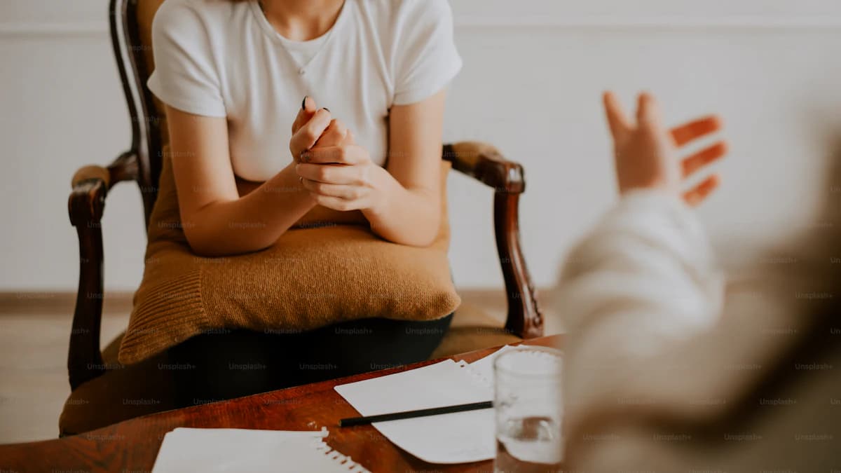 Vrouw bespreekt overgangsklachten tijdens een coachend gesprek aan tafel