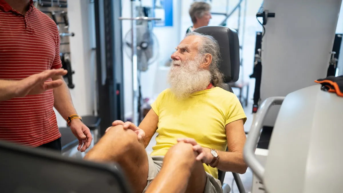Persoon in gesprek met een zorgverlener over aangepast bewegen tijdens een chemobehandeling