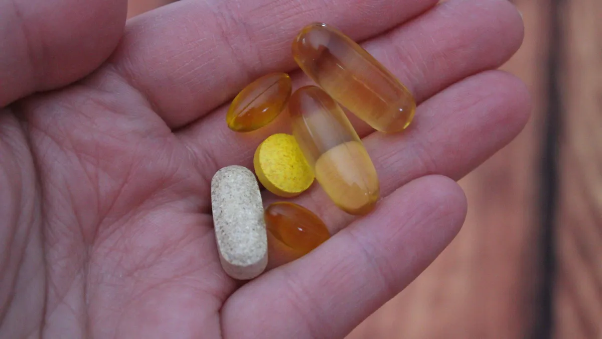 Persoon bekijkt een vingerpriktest voor vitamines thuis aan de keukentafel