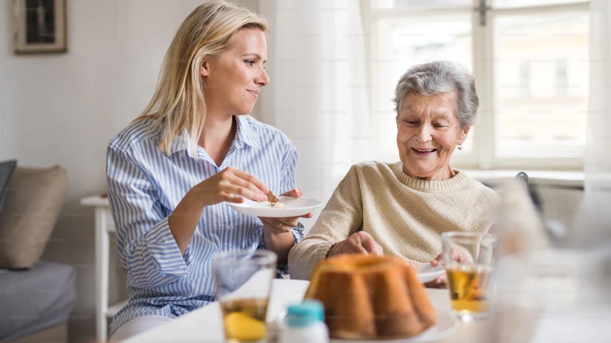 Oudere persoon met dementie aan tafel met een rustige maaltijd en begeleiding