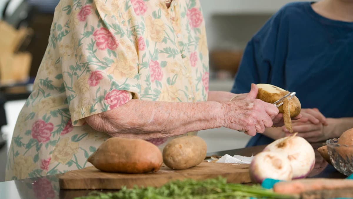 Oudere persoon krijgt aangepaste maaltijdbegeleiding aan tafel