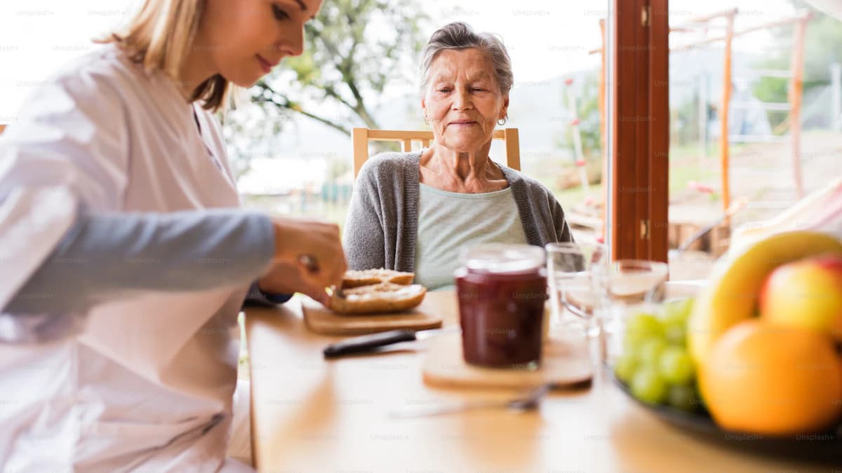 Oudere persoon en diëtist overlopen een voedingsdagboek aan tafel