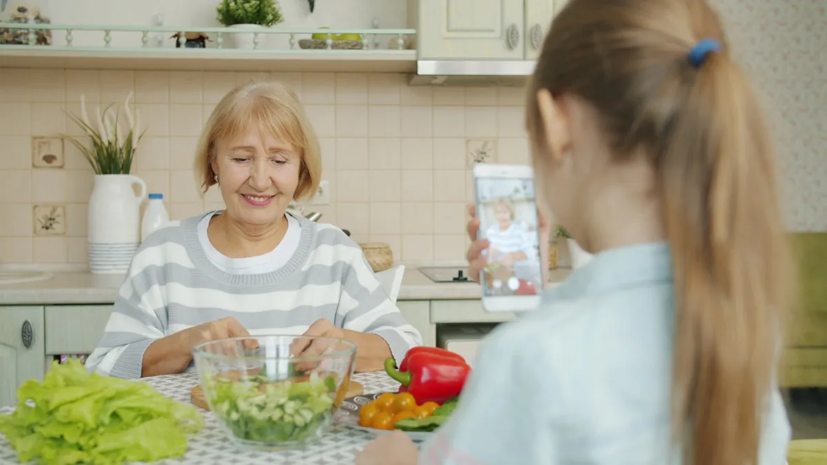 Oudere persoon en diëtist bespreken een voedingsplan aan de keukentafel