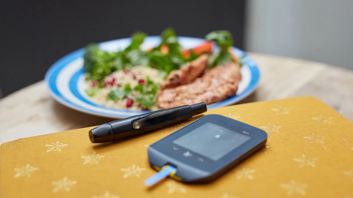 Oudere persoon aan tafel met een evenwichtige maaltijd en een glas water