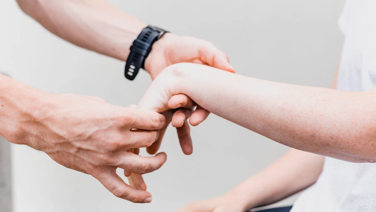 Kinesitherapeut en patient bespreken klachten en doelen tijdens een eerste afspraak