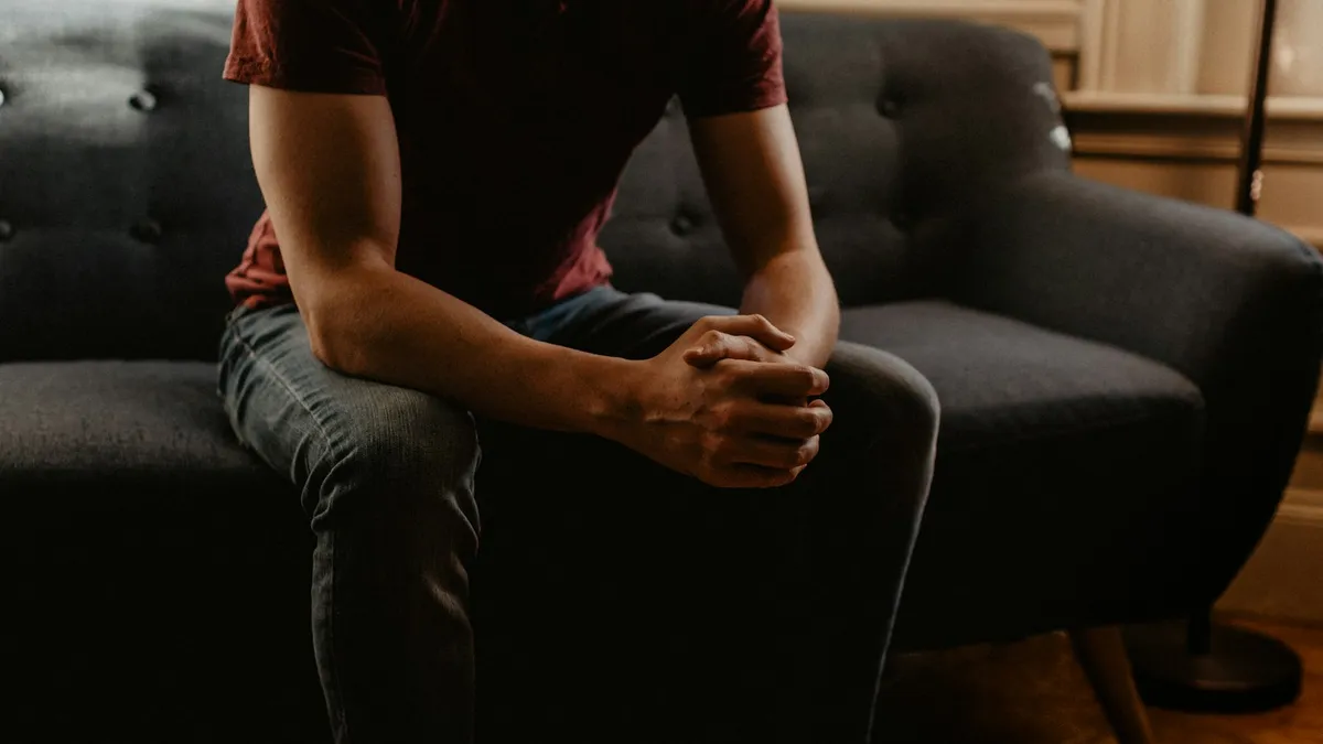 Persoon die op een laptop online beoordelingen van een psychotherapeut leest aan een tafel