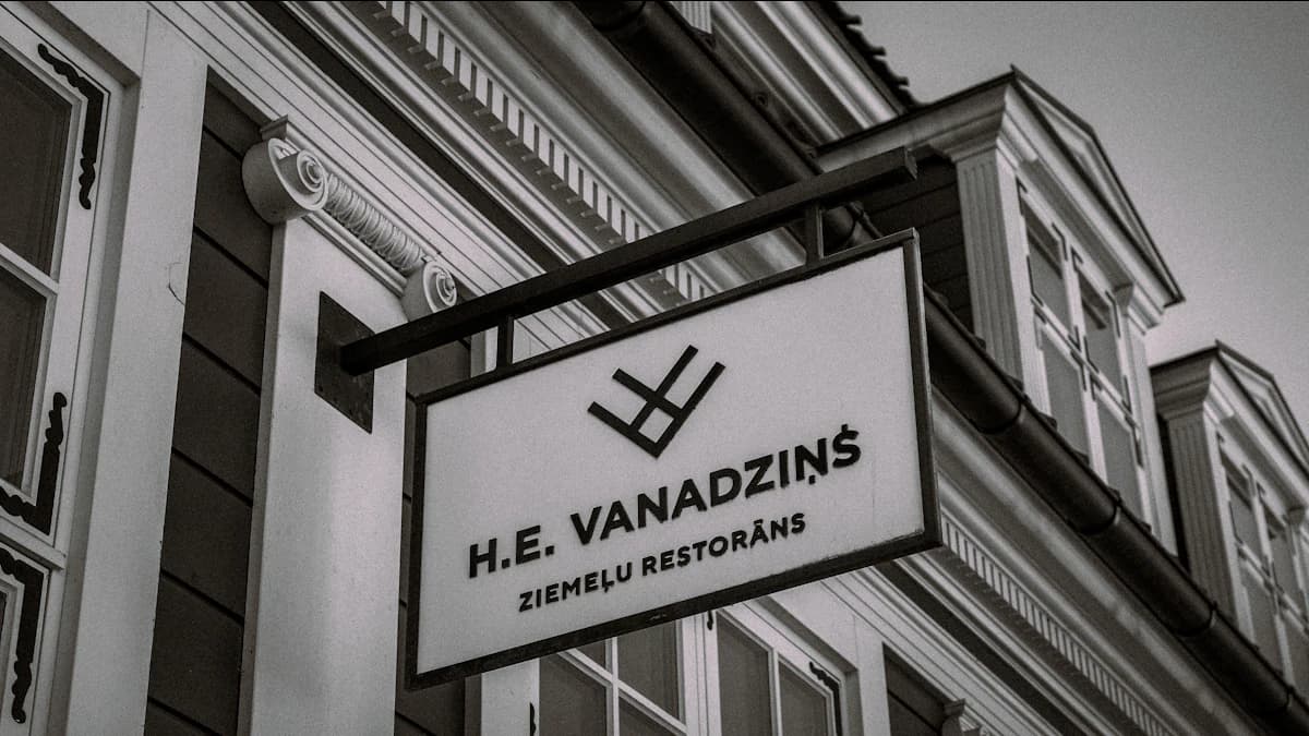 Mantelzorger helpt een oudere veilig rechtstaan in de woonkamer