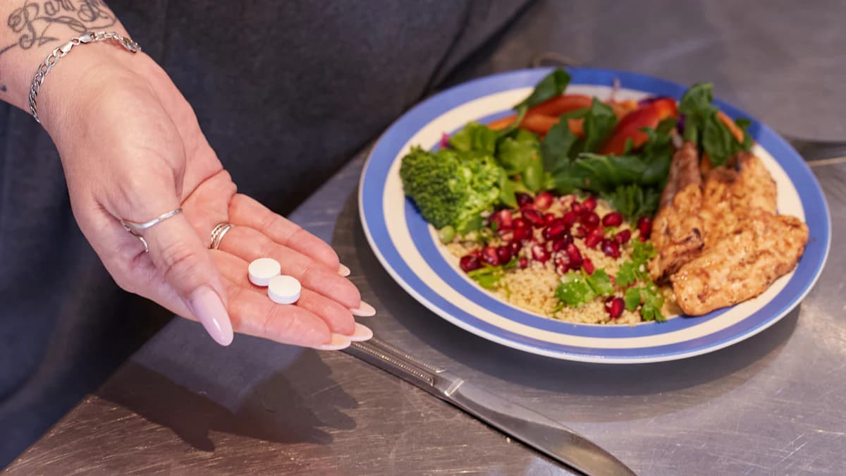Notitieboek, glas water en verse ingredienten op tafel als voorbereiding op voedingsadvies